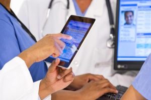 A group of physicians working on a tablet