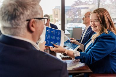 Woman handing flyer to man