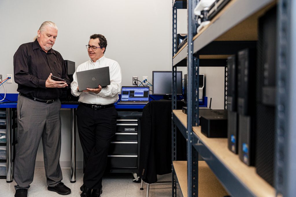 Two men holding laptops