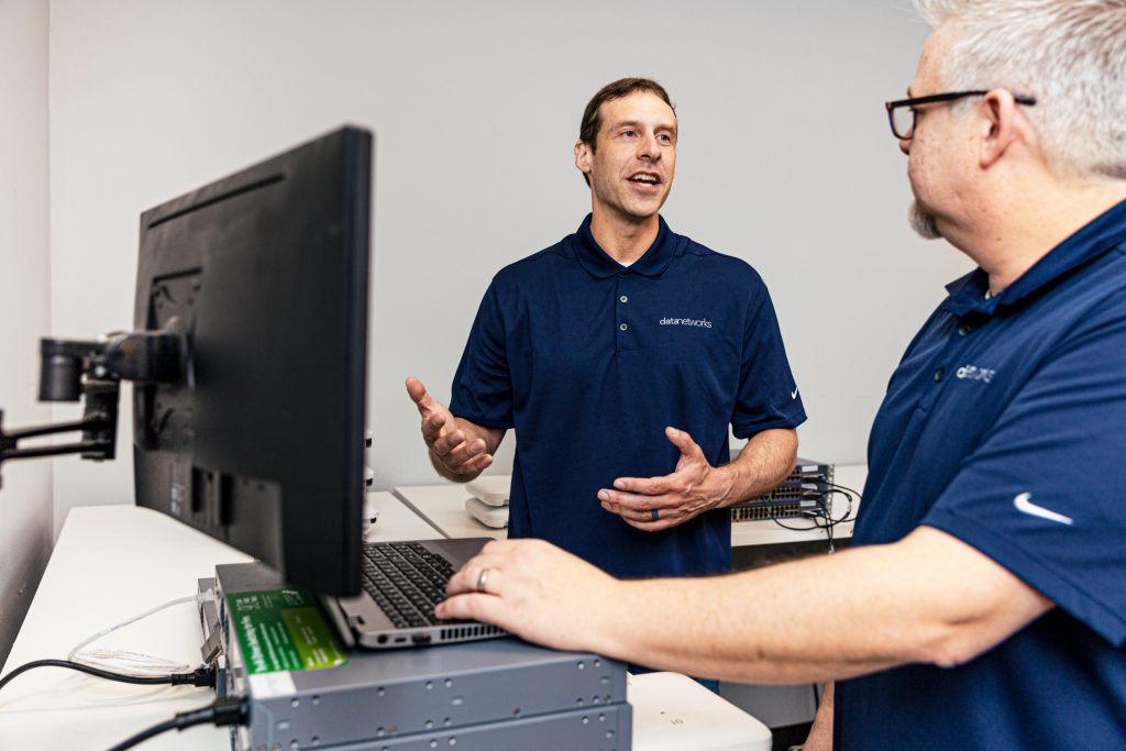 2 men discussing near computer