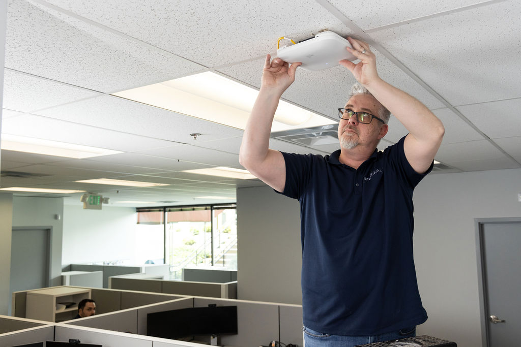 Engineer installing an Aruba wireless AP
