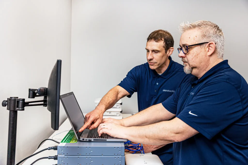 2 men working on a laptop