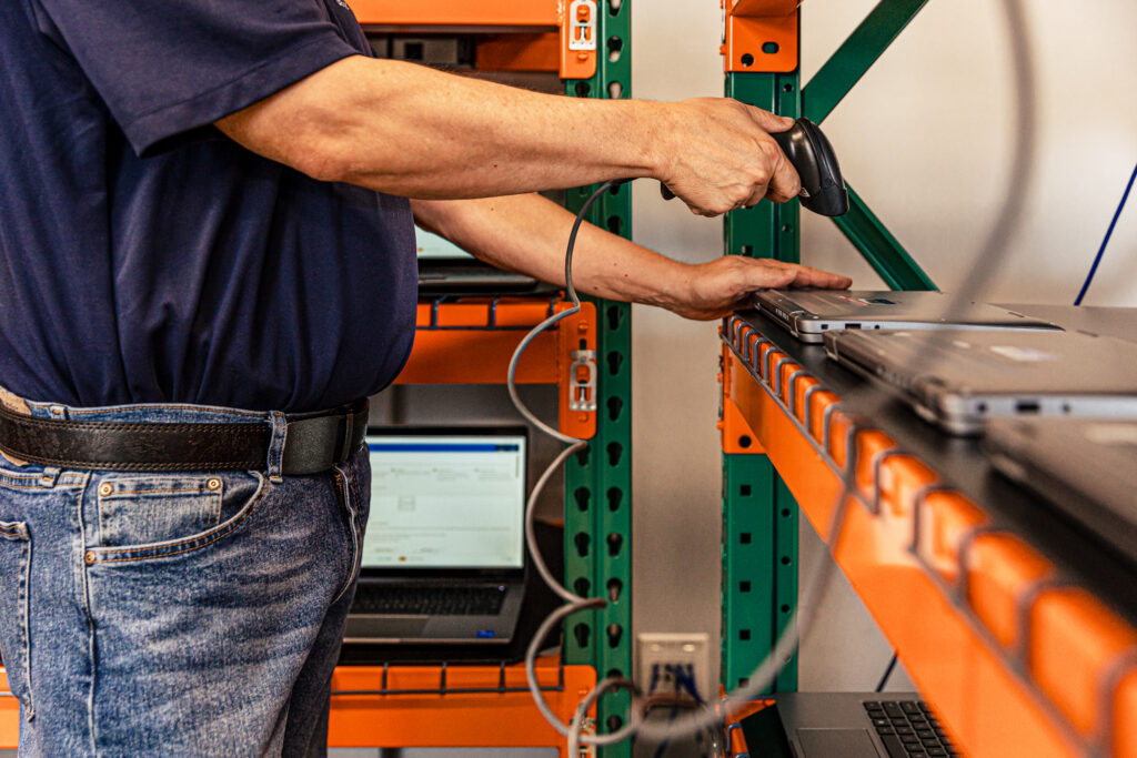Man installing asset tags for Chromebook refresh project