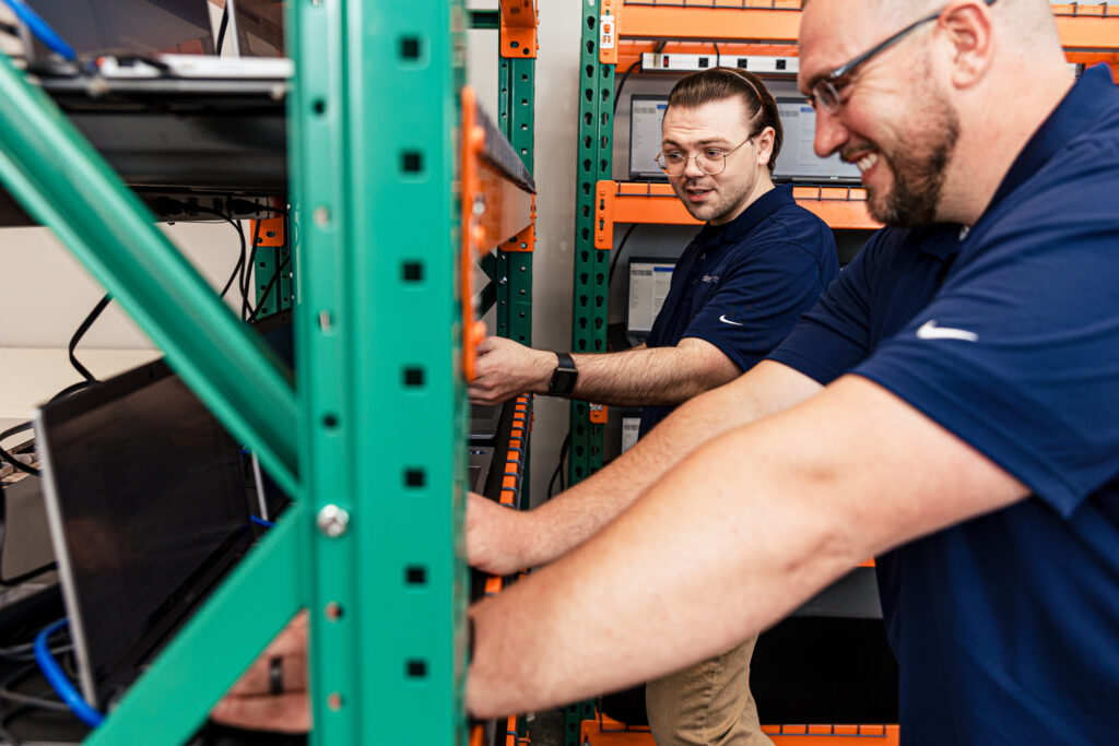 Two men performing laptop configuration services