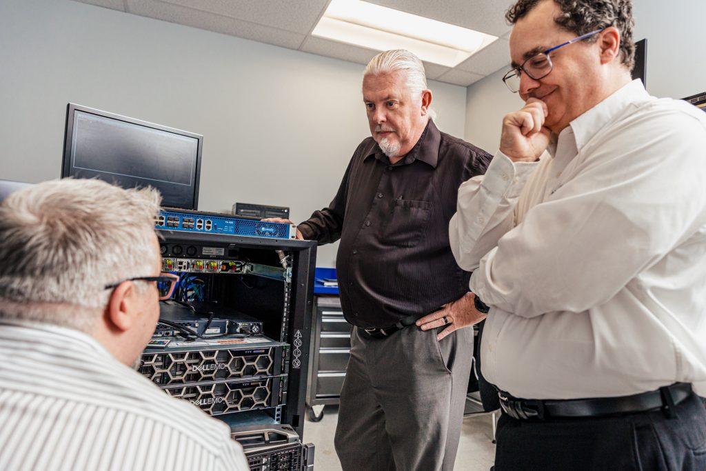 Three men working on a server